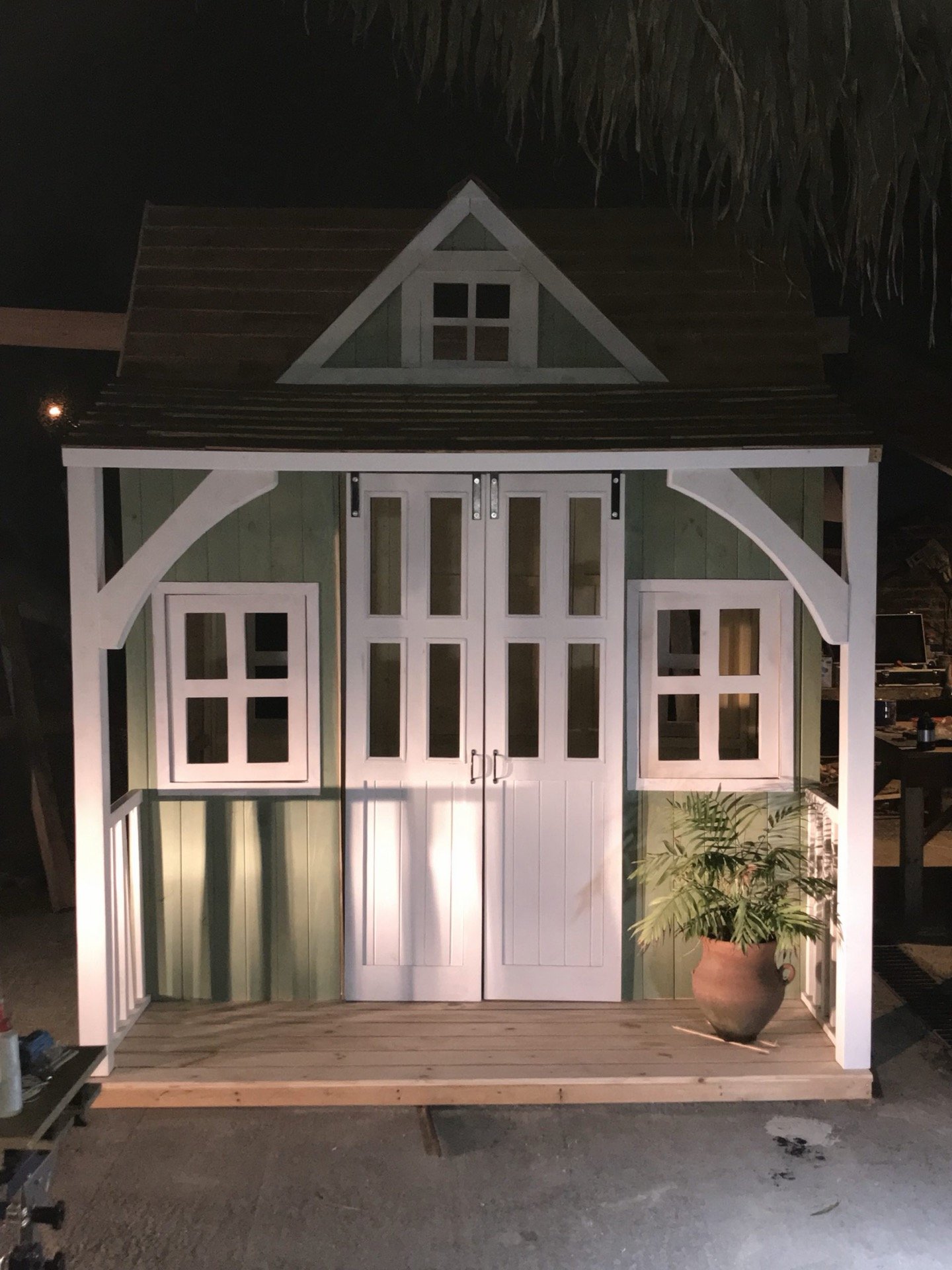 Casita con galería y puertas dobles vidriadas sobre un deck de madera
